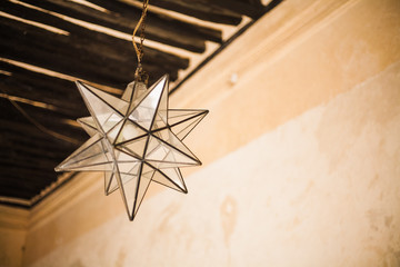 lámpara en forma de estrella de cristal colgada de techo con vigas