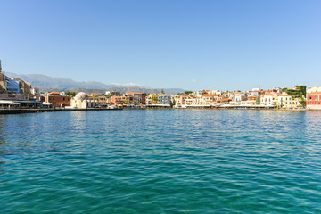 Gastronomy in the old buildings of the harbor promenade of Chania. On left, the famous Hasan Pasha Mosque in the old town