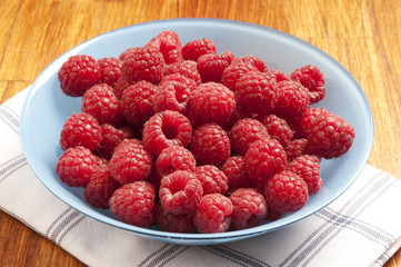 red raspberries in bowl with rustic dishtowel, summer fruit 