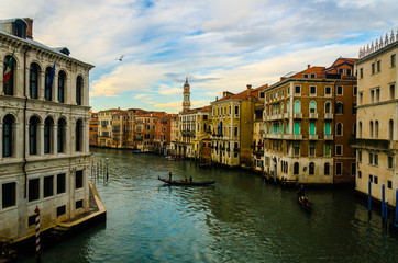 Narrow water lane river with old historical residential building houses and boats during sunrise in Venice Italy for romantic honeymoon holiday visit vacation