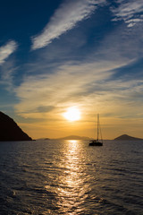 Boat and sun rise over Greek island