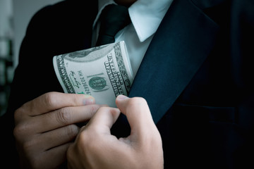 Asian business individual who owns the business sign personally sealing the deal with receiving a bribe money.The concept of corruption and anti bribery