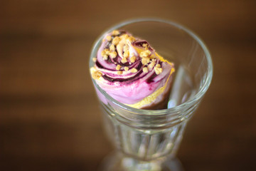 Pink and yellow strawberry banana cone of delicious ice cream in a glass glass top view