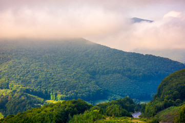 Naklejka premium beautiful mountain landscape in low clouds. peak of the mountain in the distance among the clouds. beautiful morning landscape