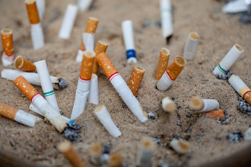The cigarette butts are discarded. Cigarettes are the cause of oral cancer. Smoking is a cause of cancer
