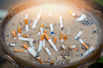 The cigarette butts are discarded. Cigarettes are the cause of oral cancer. Smoking is a cause of cancer
