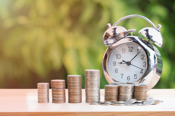 Close up of time and money with green bokeh background ,Business Finance and Money concept,Save money for prepare in the future.time is money concept