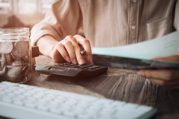 Close up asian business woman using a calculator to calculate the numbers.Business finances and accounting concept