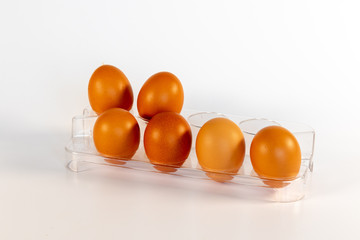 Six brown chicken eggs in a plastic eggbox out of the fridge
