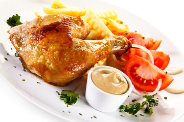 Roast chicken leg with french fries on white background