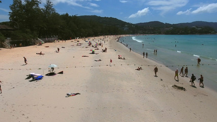 Obraz premium PHUKET, THAILAND - 20 JAN 2017: Aerial view of crowd of tourists get rest on sea beach near little village at summer sunny day