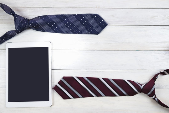 Happy Father's Day inscription with colorful tie and digital tablet on wooden background floor backround.