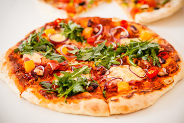 Pizza with ham and vegetables on wooden table