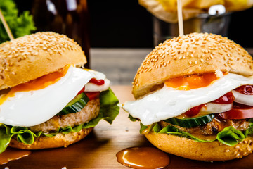 Tasty burgers with chips served on cutting board