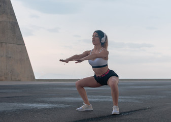 Chica haciendo sentadilla al aire libre