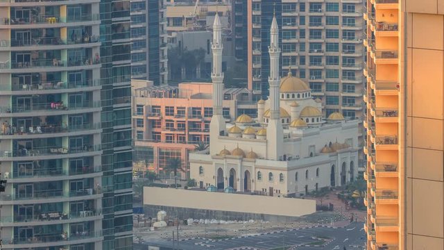 Al Raheem mosque between skyscrapers timelapse on the marina walk in Dubai Marina, Dubai, UAE.