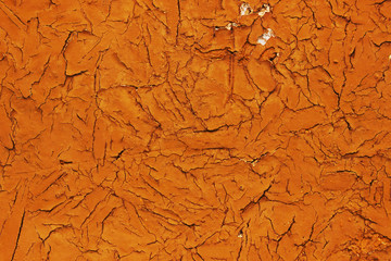 Texture or background, cracks on a yellow-orange paint on a concrete wall