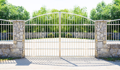 Chrome fence gate. Chromium Stainless steel fence on stone wall