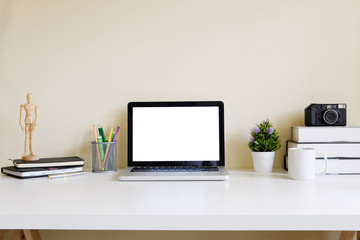 Mockup blank screen computer laptop on desk. Workspace with laptop and office supplies.
