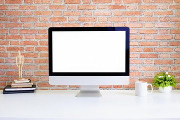 Fototapeta premium Workspace computer pc and coffee mug on white table and brick wall with empty screen display.