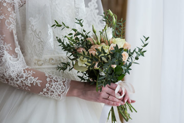 bouquet in hands of the bride, woman getting ready before wedding ceremony