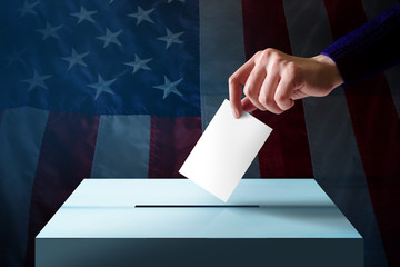 Election in America Concept. Hand Dropping a Ballot Card into the Vote Box, Flag of United States as background