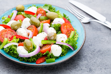Vegetable salad with cheese mozzarella, tomatoes, basilikum and spice.