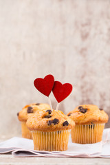 Homemade chocolate muffins with heart, vintage background.