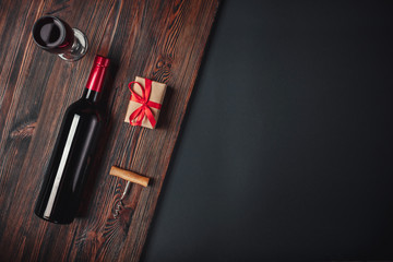 Bottle of wine gift box corkscrew and wineglass on rusty background