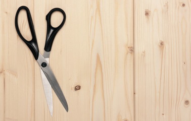 tailor's metallic scissors on light coloured  wooden background