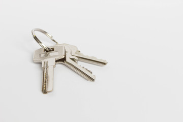 A bunch of three metal keys on a white background