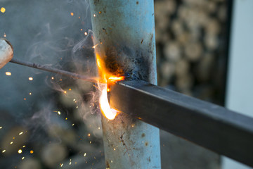 worker welding metal elements on site
