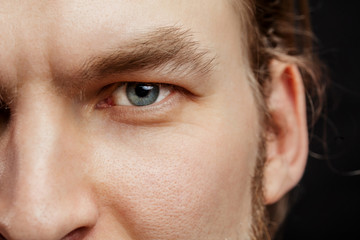 close up cropped photo of man bearded face with beautiful blue eyes