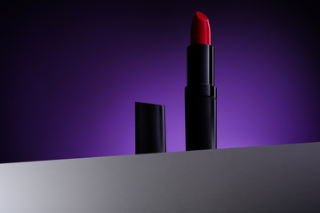 red glossy lipstick with purple violet background