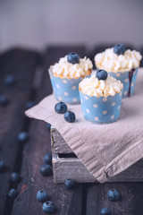 three blueberry cupcakes, rustic style, cool vintage effect, berries, on linen cloth, old wooden 