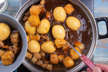 Chef putting streaky pork in pot to bowl