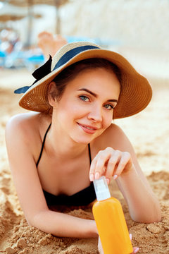  Sexy Young Woman in Bikini  Holding  Bottles of Sunscreen in Her Hands. Skincare. A Female  Applying Sun Cream Creme.Sun protection
