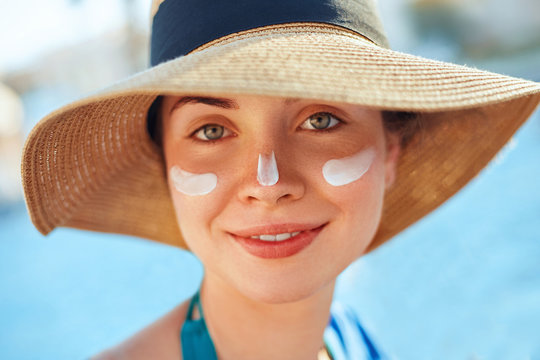 .Suntan Lotion Woman Applying Sunscreen. Female smear  sun cream  on face. SkinCare.