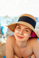 Facial Care. Female Applying Sun Cream and Smiling. Beauty Face.  Portrait Of Young Woman in hat Smear  Moisturizing Lotion on Skin. SkinCare