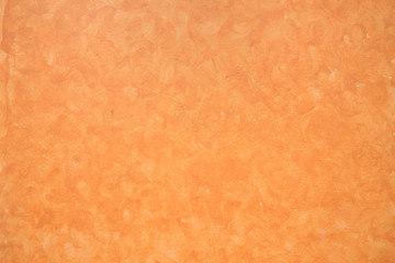 Part of painted orange color cement wall.