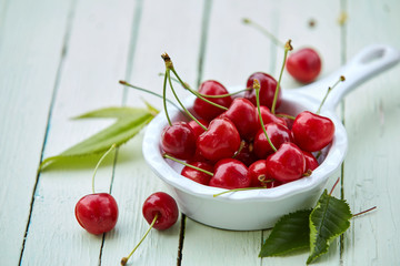 Obraz na płótnie Canvas Small pannikin filled with ripe red sweet cherries