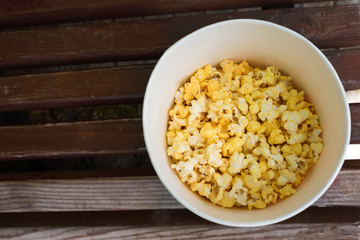 Popcorn bucket on a bench. Top view
