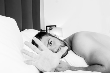 Shirtless sexy hunky man with beard lies naked in bed
