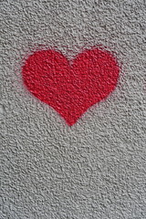 cœur rouge sur mur granuleux de couleur crème