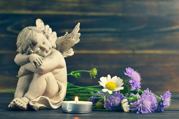 Angel, candle and wildflowers