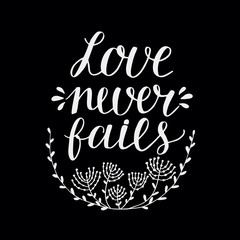 Hand lettering Love never fails made with flowers and leaves on black background