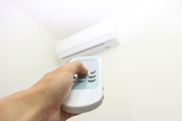 室内の白いエアコンとリモコン Turn on and off an air conditioner in a room