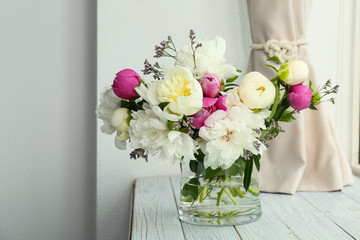 Vase with bouquet of beautiful flowers on wooden table