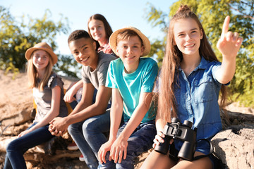Group of children with binoculars outdoors. Summer camp