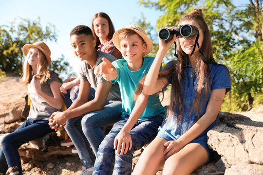 Group of children with binoculars outdoors. Summer camp